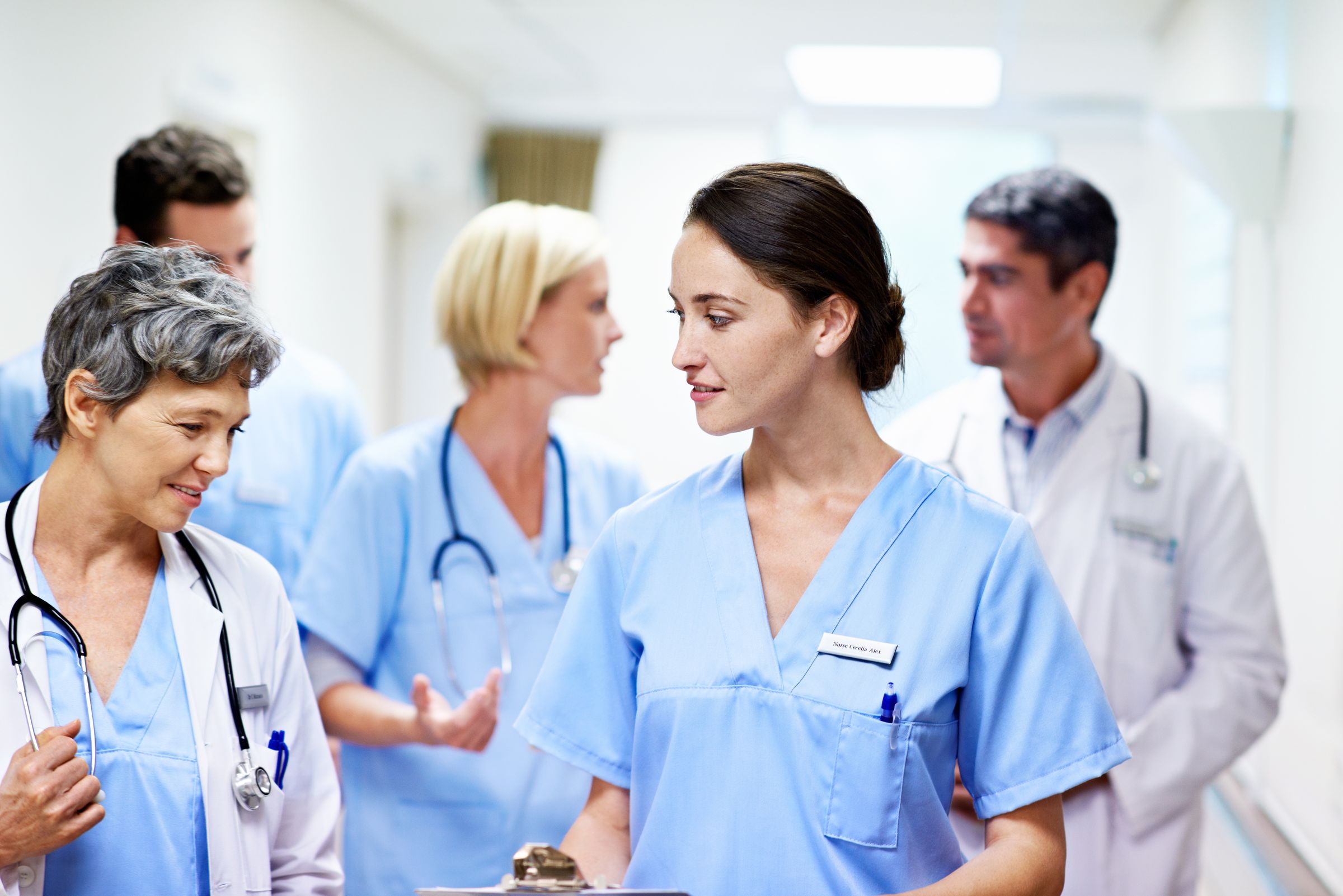A clinic team of nurses and doctors talking in a corridor