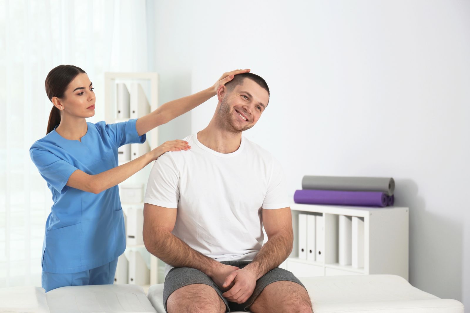 A therapist examining a smiling patient